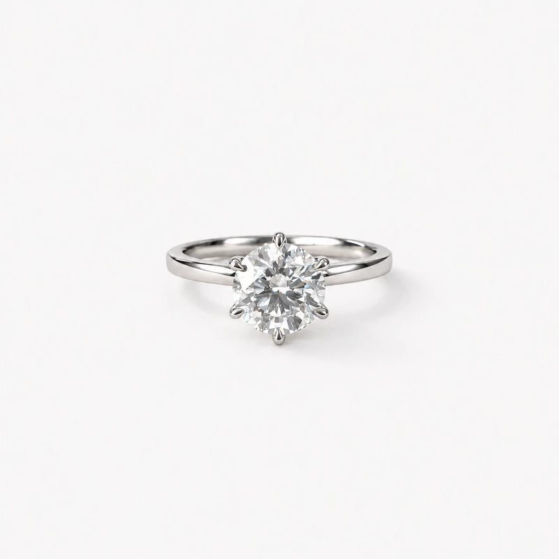 GISELLE Round Cut Signature Skinny Setting in Platin oder Weissgold, frontal liegend, mit rundem 1.30-ct-Diamanten und sechs Krappen.